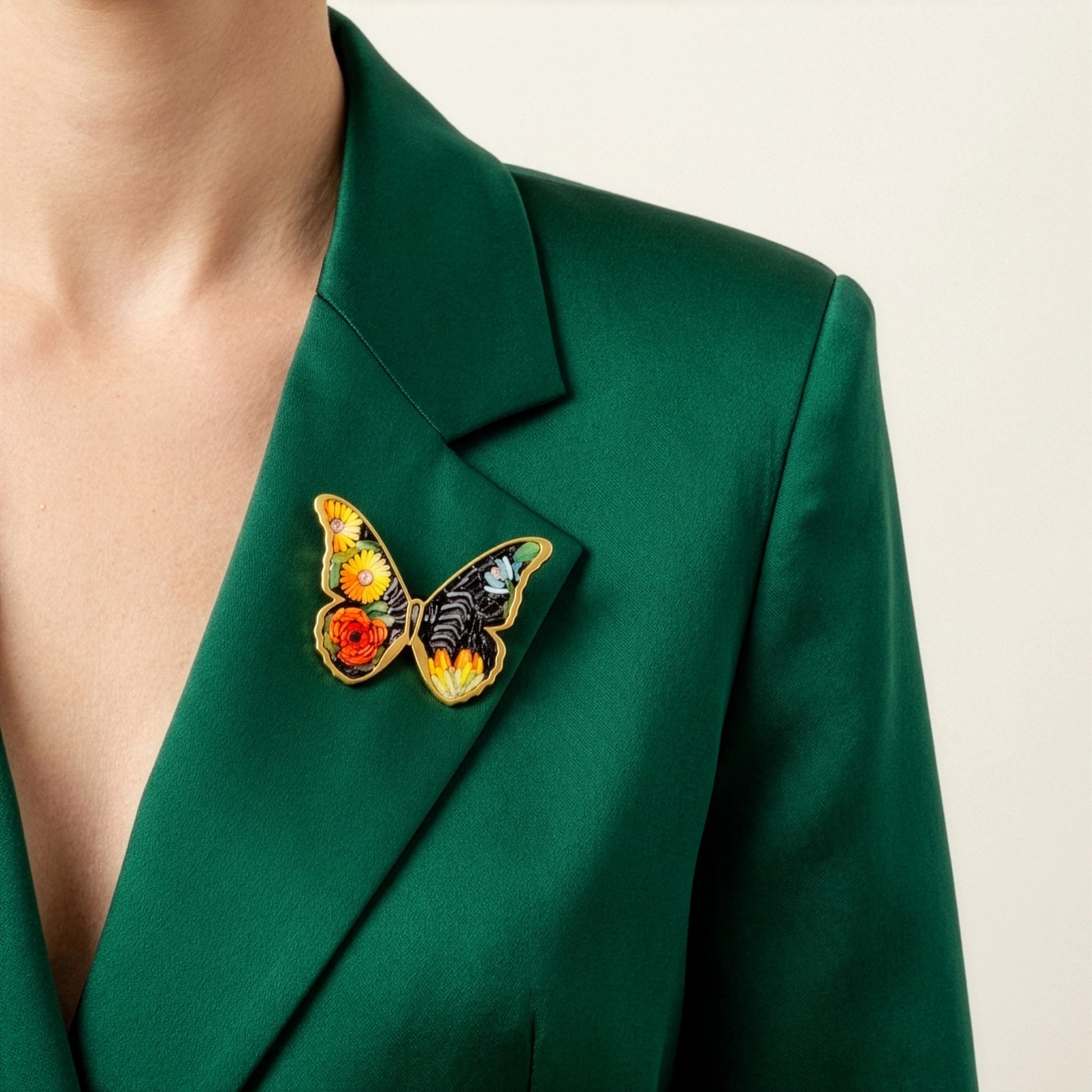 Green blazer with a butterfly brooch on a neutral background
