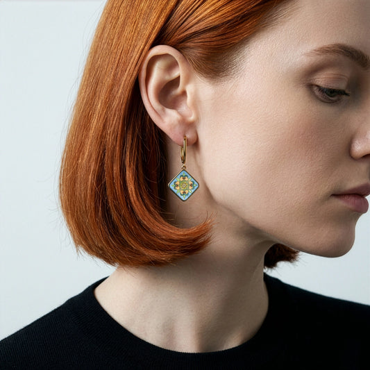 Close-up of a person wearing a decorative earring with a plain background